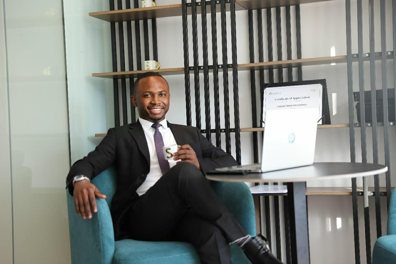 Kúnlé Ìlòrí-Diamond, real estate investor and strategist, seated in an armchair in a dark suit.
