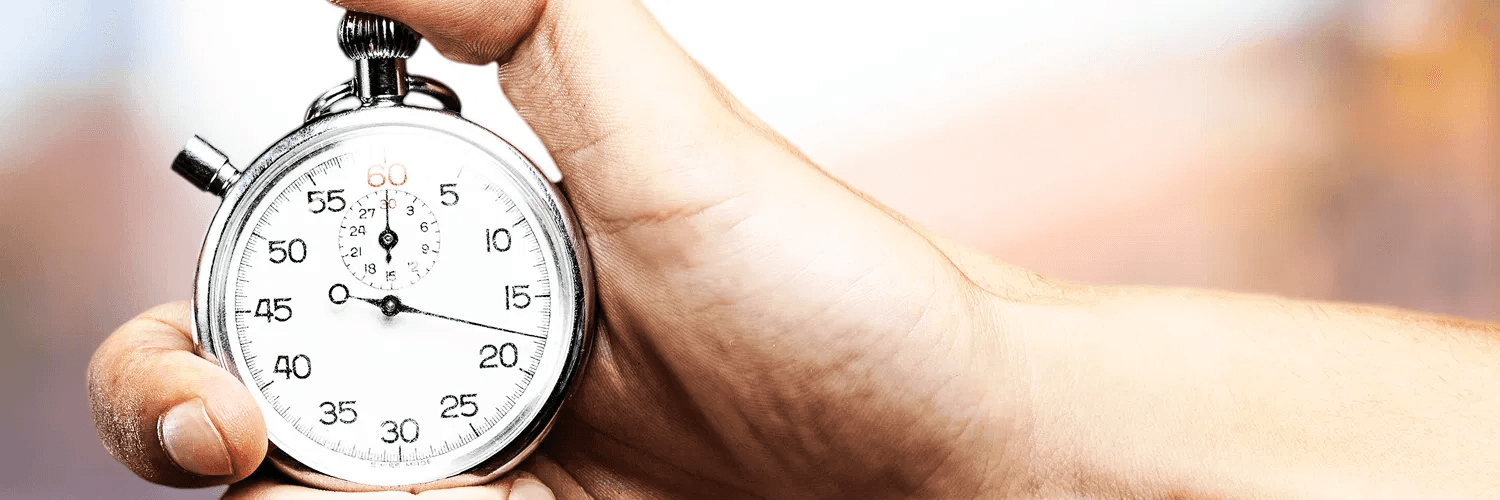 A hand holding a silver stopwatch with the second hand running, on timing a property negotiation.